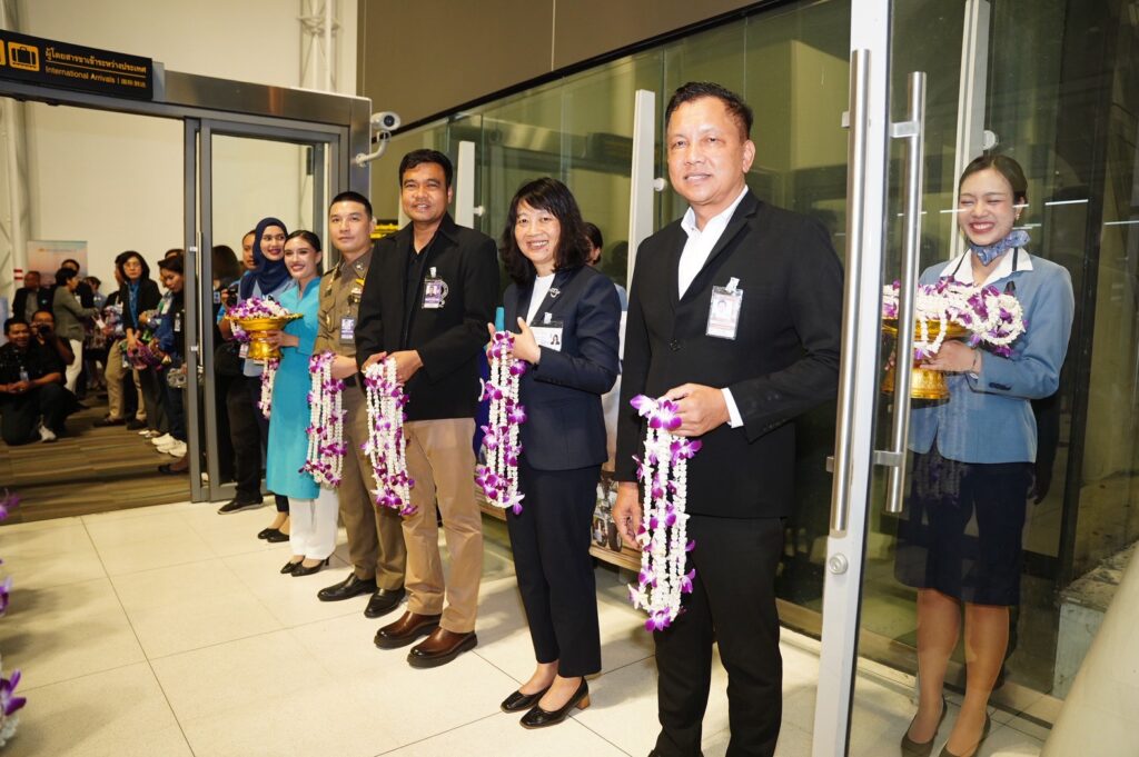 TAT representative welcomes arriving Vietnam Airlines passengers with floral garlands at Phuket International Airport.