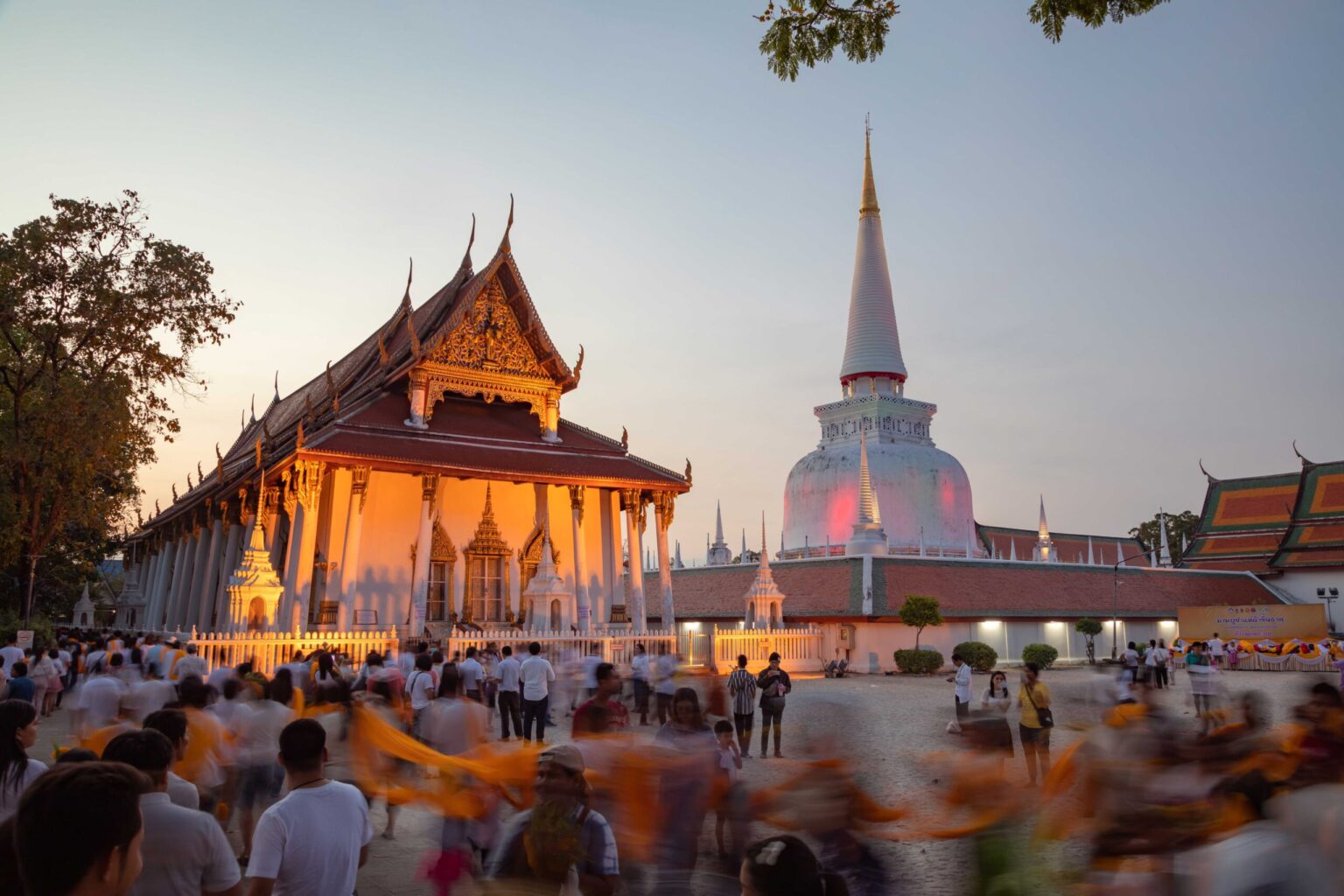 Visitors gather at Wat Phra Mahathat Woramahawihan in Nakhon Si Thammarat during an evening Buddhist ceremony.