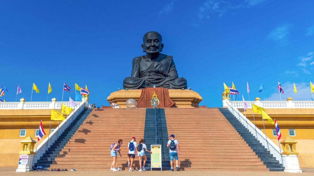 Visitors approach the giant Luang Pu Thuat statue at Wat Huai Mongkhon