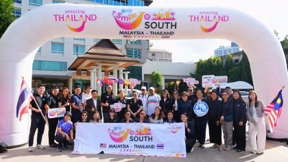 TAT officials and participants gather under the Smile @ South Malaysia–Thailand Caravan arch during the flag-off ceremony in Hat Yai, Songkhla.