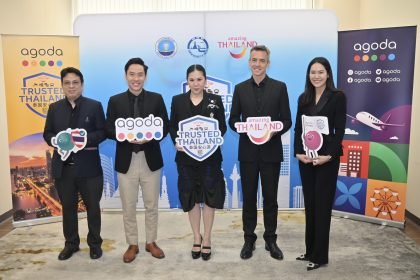 Group photo of representatives from the Tourism Authority of Thailand and Agoda standing before Trusted Thailand and Amazing Thailand backdrops, holding campaign signage during the partnership meeting in Bangkok.