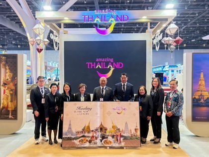 Group photo at the Thailand pavilion during Outbound Travel Mart 2026 in Mumbai, showing Tourism Authority of Thailand executives and staff beneath the Amazing Thailand branding and the Healing is the New Luxury campaign backdrop.