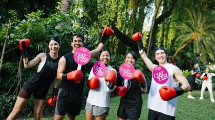 Participants celebrate Global Wellness Day 2026 with Muay Thai-inspired wellness activities in a tropical Thailand setting.