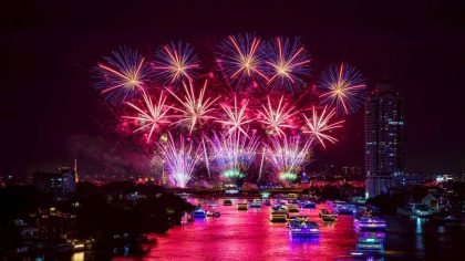 Fireworks illuminate the Chao Phraya River during the closing night of Vijit Chao Phraya 2025, with illuminated cruise boats and Bangkok’s skyline reflecting vibrant colours along the river.